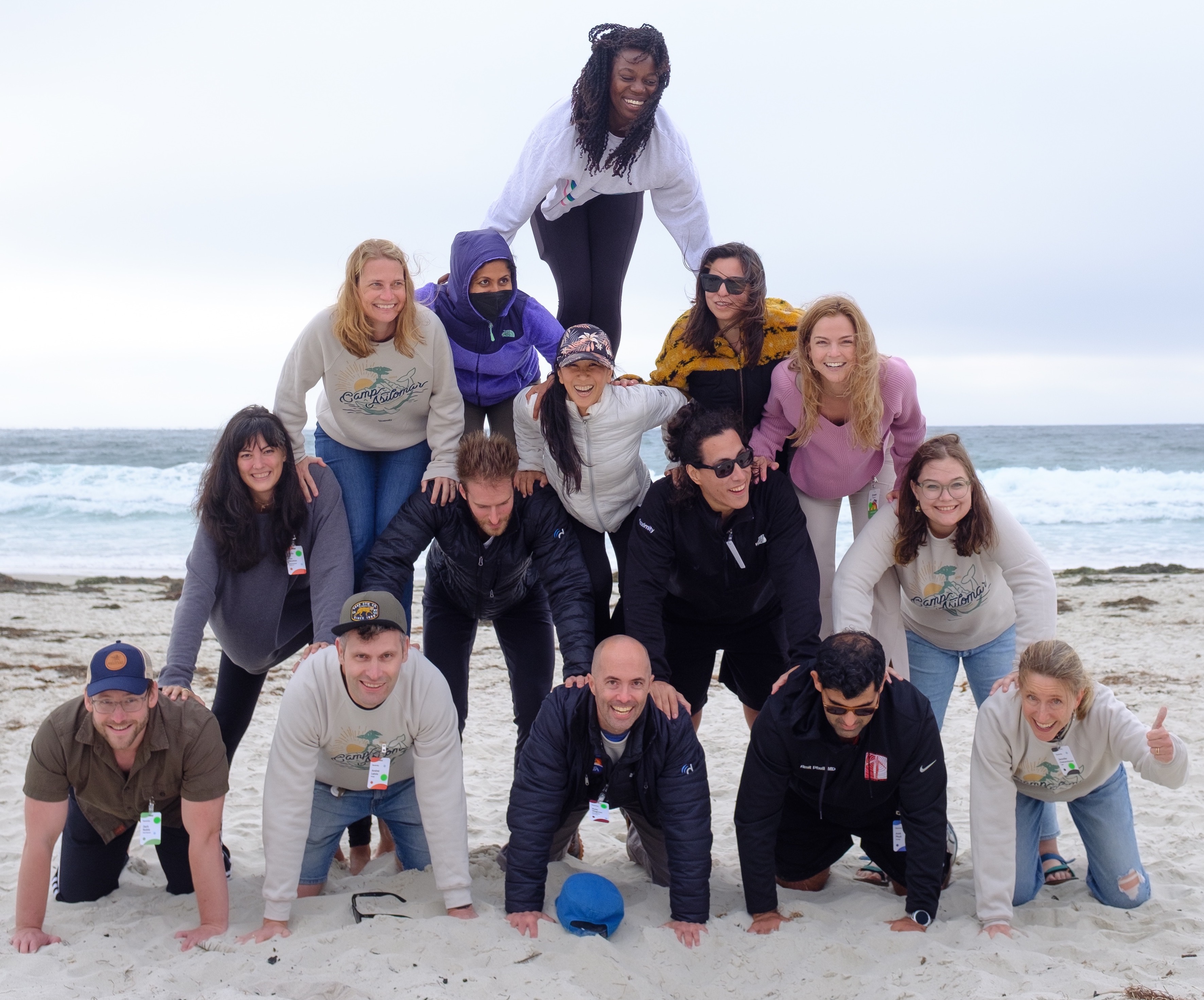 Photo of the Doximity team in a human pyramid on the beach. 
