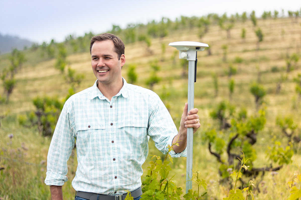 Arable CEO Jim Ethington next to his company's sensors in a field.