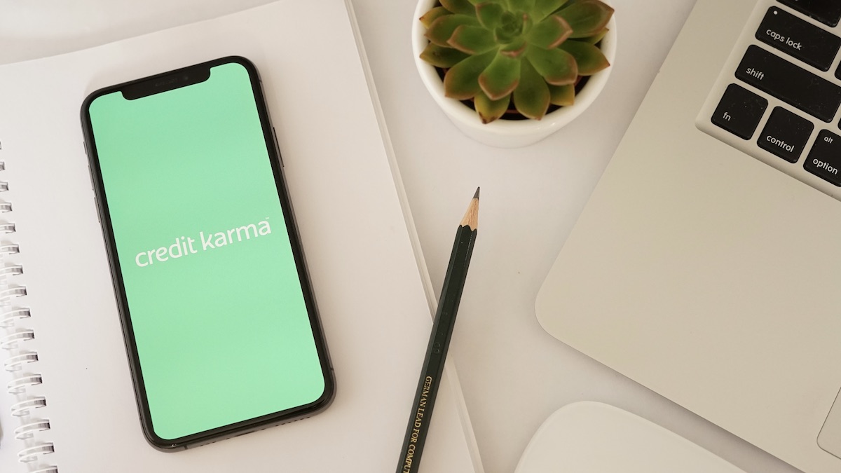 A phone shows a green screen with Credit Karma's logo