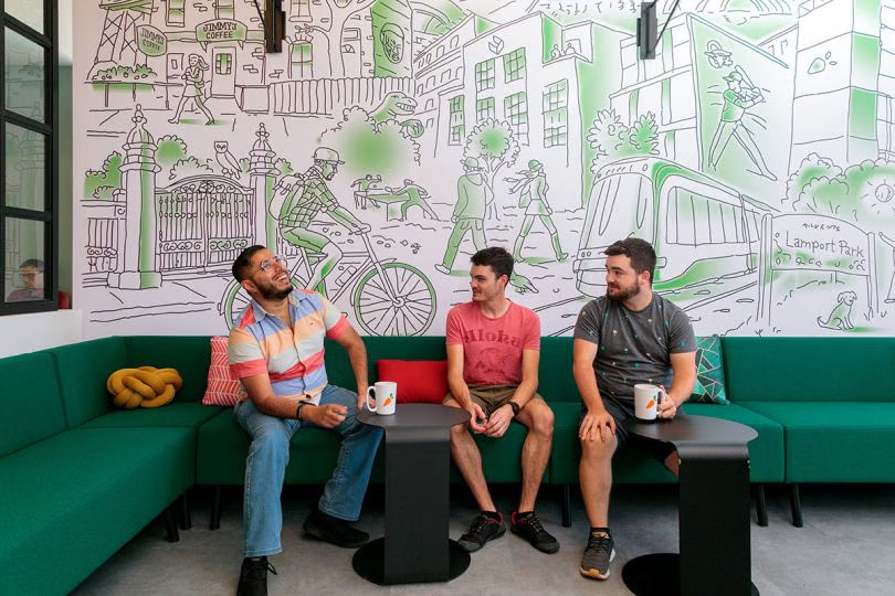 Three employees chat in the office at Instacart.