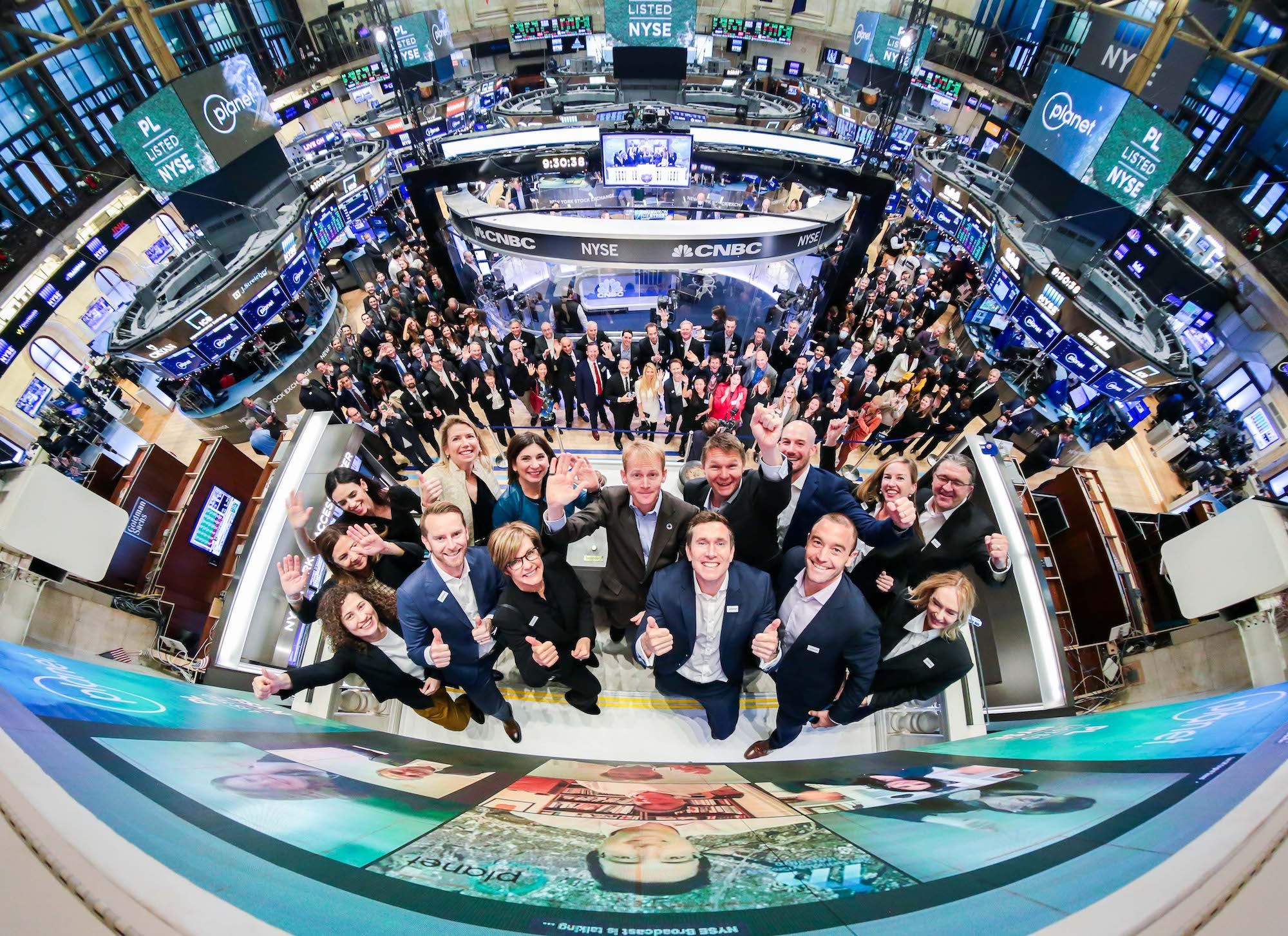 A panoramic photo of the Planet team members at a Nasdaq listing event.