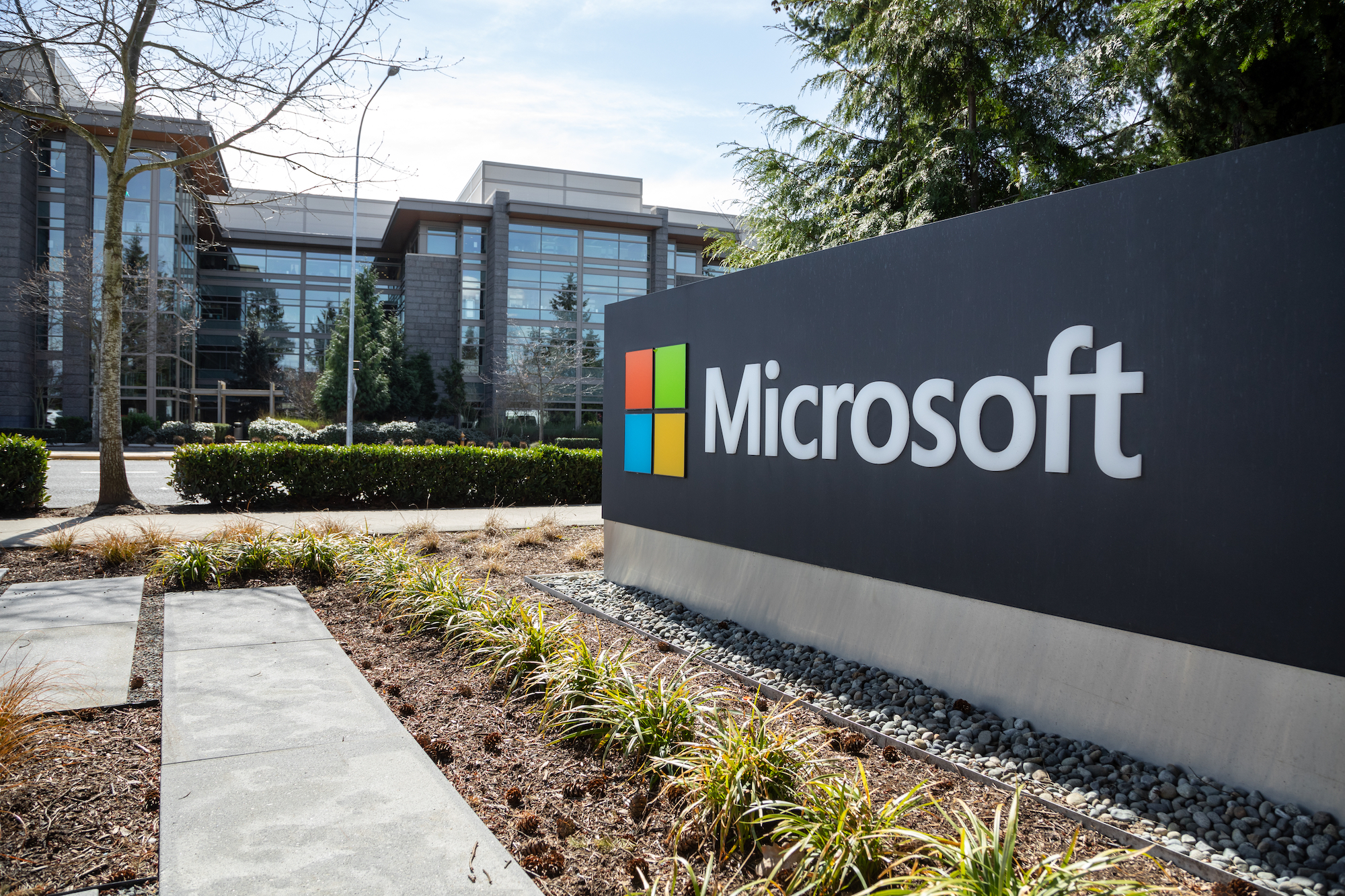 Wide angle view of a Microsoft sign at the headquarters for the software and hardware company, with office building in the background