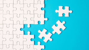 White puzzle pieces being assembled on a bright blue background