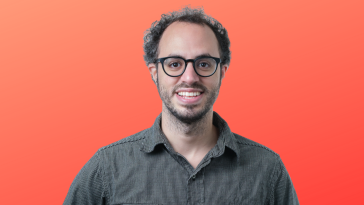 Clerk’s founder and CEO Colin Sidoti poses for a photo against an orange background.