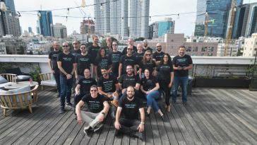 Members of the Descope team pose together on an urban rooftop for a group photo.