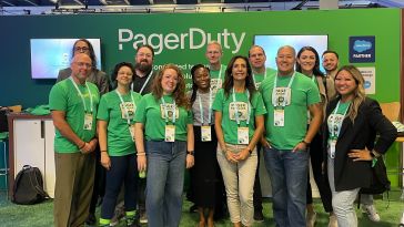 PagerDuty team members in green shirts in front of PagerDuty booth at a conference