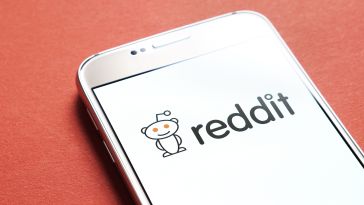 The Reddit logo on a phone screen is pictured.